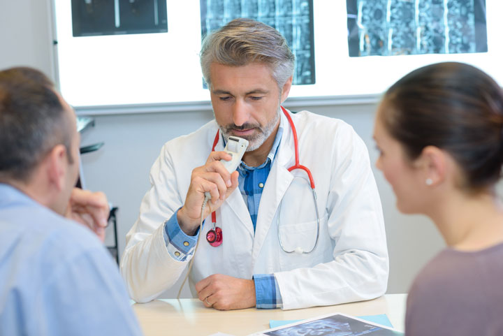 Ein Arzt spricht mit einem Patienten in einem Untersuchungsraum